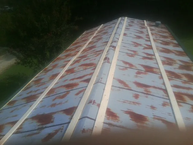 Rusted metal roof panels with new wood purlins before replacement — Storm Damage Roof Repair in Wyatt by Roofing Brothers