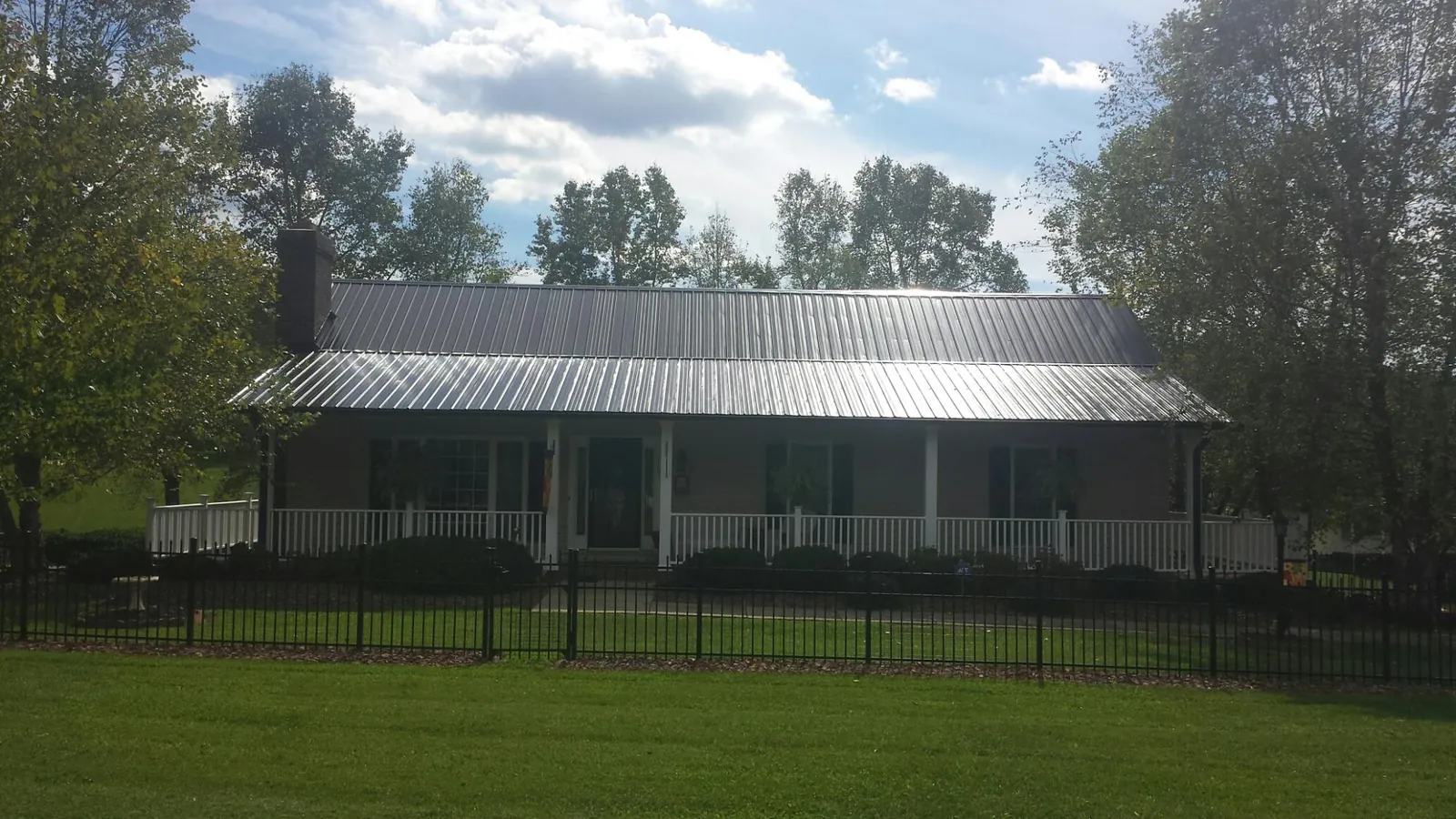 Gray metal roof on a brick ranch with a full width front porch in Wyatt
