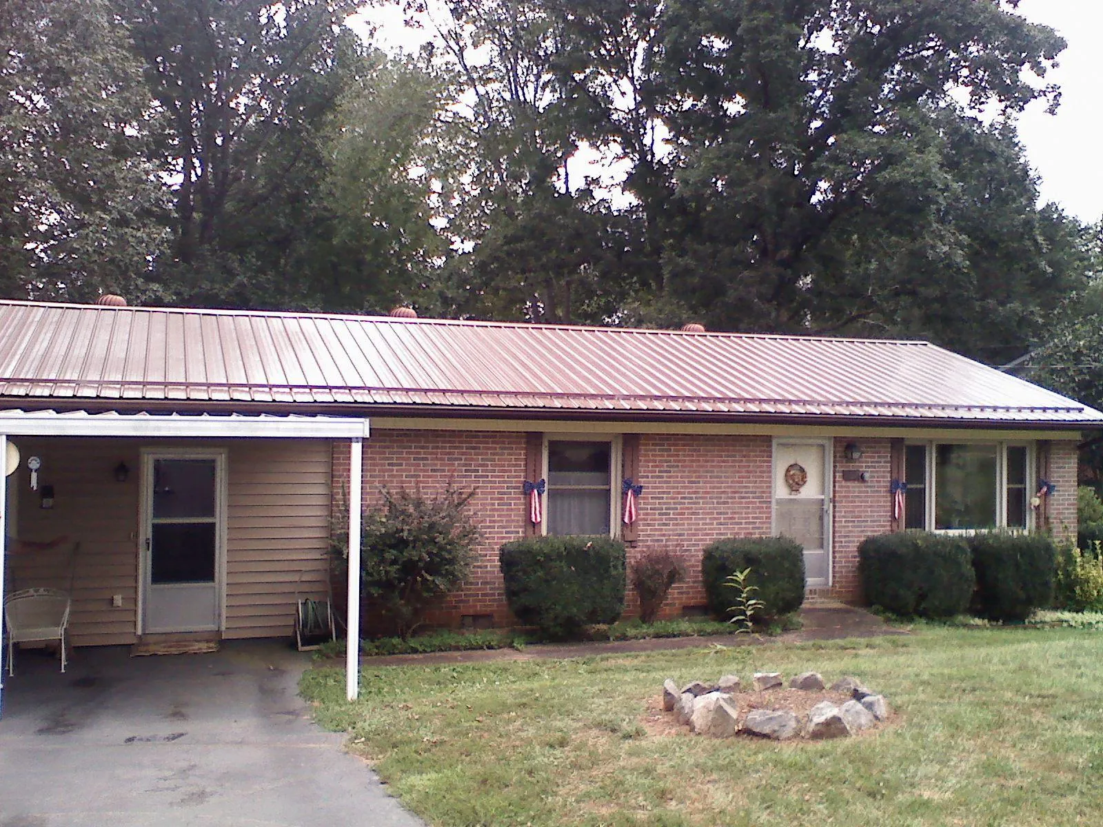 Bronze metal roof and carport on a brick ranch home — Roof Repair work by our crew in Wyatt